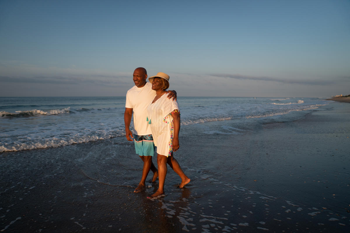 Couple walking down the beach at sunrise