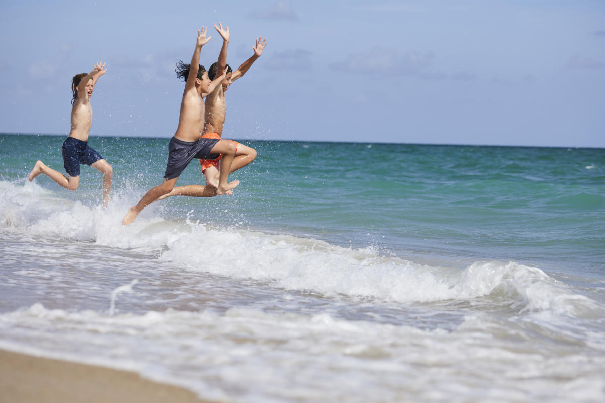 Boys jumping into the ocean