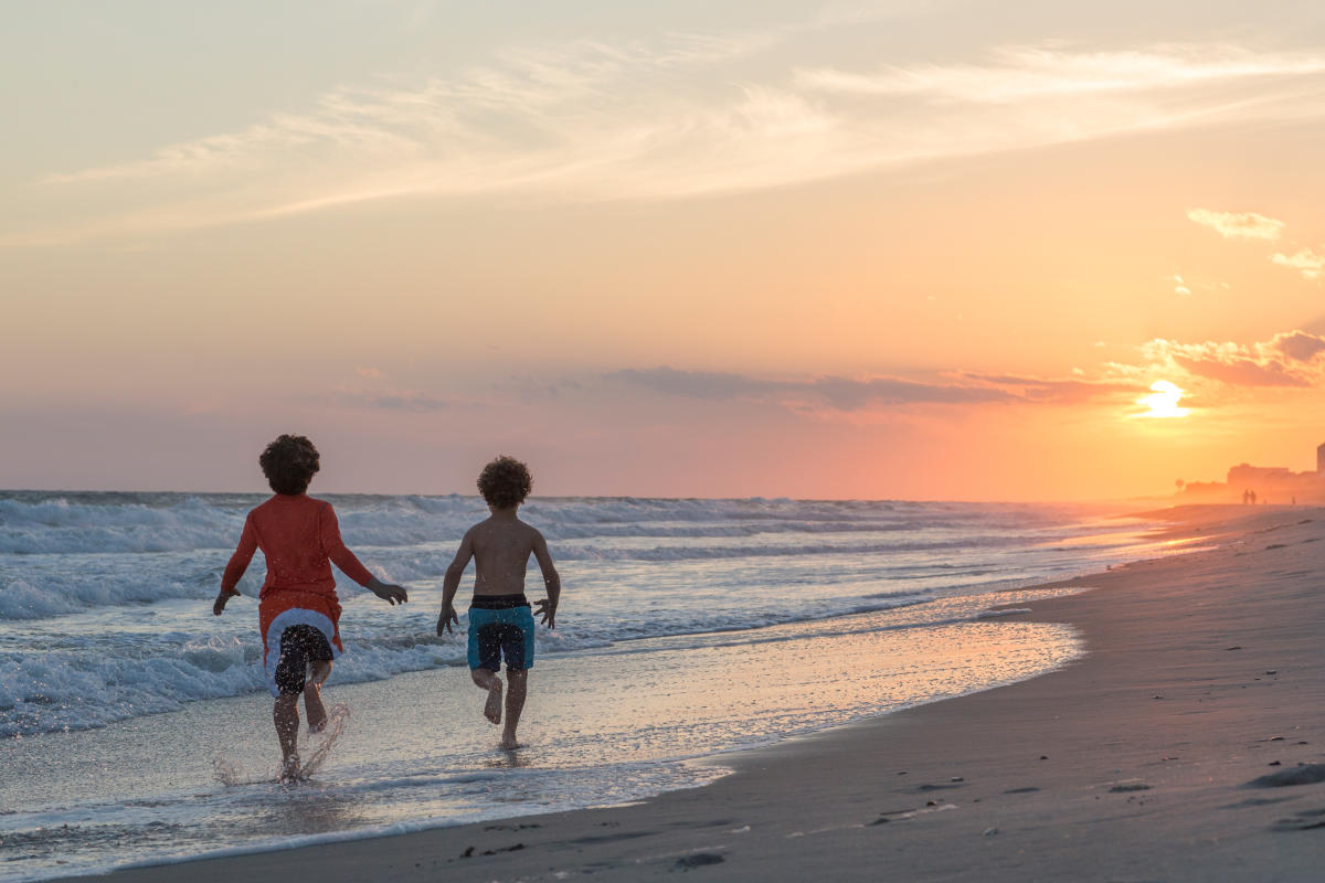 Kids running into the sunset