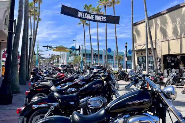 A group of people and motorcycles on Main Street in Daytona Beach, Florida during Bike Week.