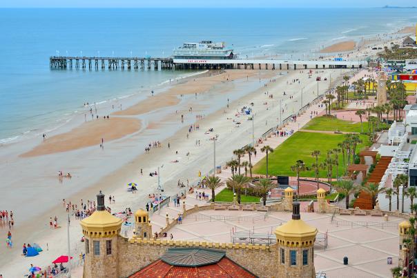 An aerial view of the wide Daytona Beach coastline and the Daytona Beach Pier and Oceanfront Bandshell