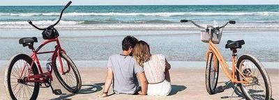 A couple takes a break from bicycling on the beach and enjoys quiet time