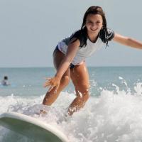 Young girl surfing of the coast of Daytona Beach