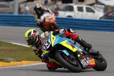 The number 13 motorcycle racer corners the track during the Daytona 200 race at Daytona International Speedway