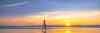Lady walking on the beach at sunrise