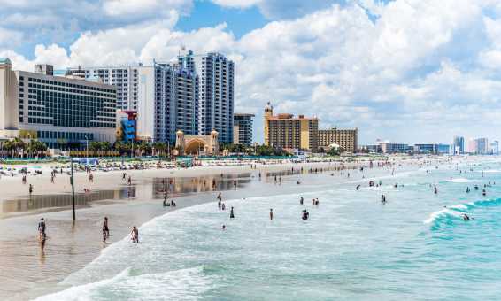 Visitors to Daytona Beach in the Atlantic Ocean by the Boardwalk and Pier.