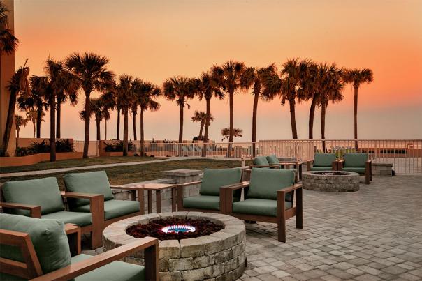 An inviting cozy atmosphere at an oceanfront hotel with soft seating and fire pits