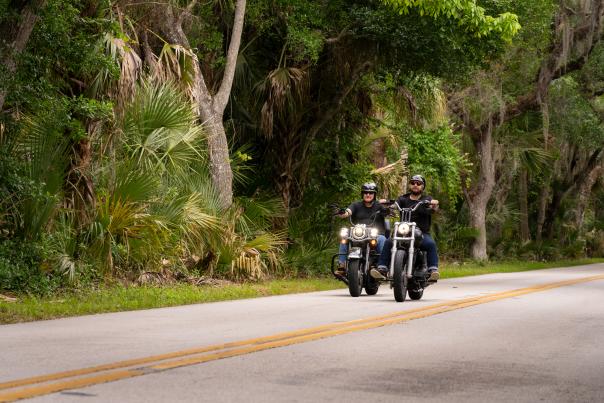 Motorcycle riders riding The Loop, a 34-mile tree lined scenic route, during Biketoberfest in Daytona Beach, Florida.
