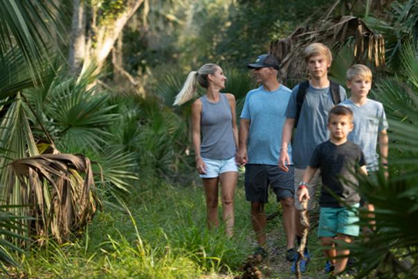 A family of five enjoys a hike.