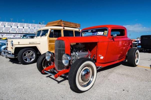 Red classic car parked next to a white classic car