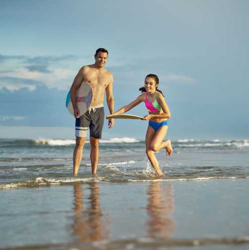 Father and Daughter on Beach SkinBoarding