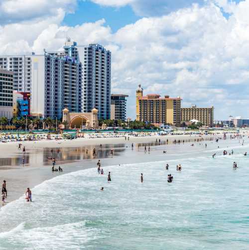 Visitors to Daytona Beach in the Atlantic Ocean by the Boardwalk and Pier.