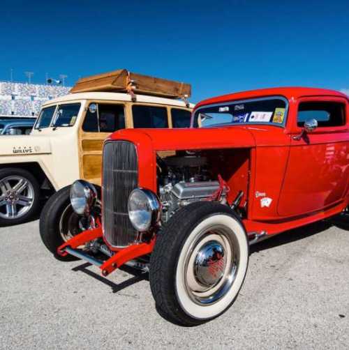 Red classic car parked next to a white classic car