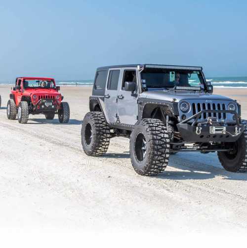 Jeeps driving on the beach during Jeep Beach in Daytona Beach