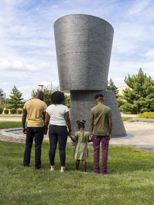 A family paying respects at a monument