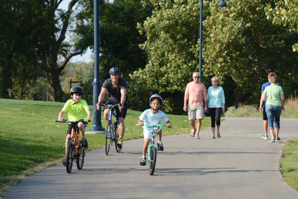 Kids Biking down trail with parents walking behind them
