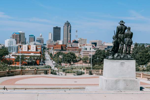 View of the statue outside the Iowa State Capitol and the Des Moines Skyline