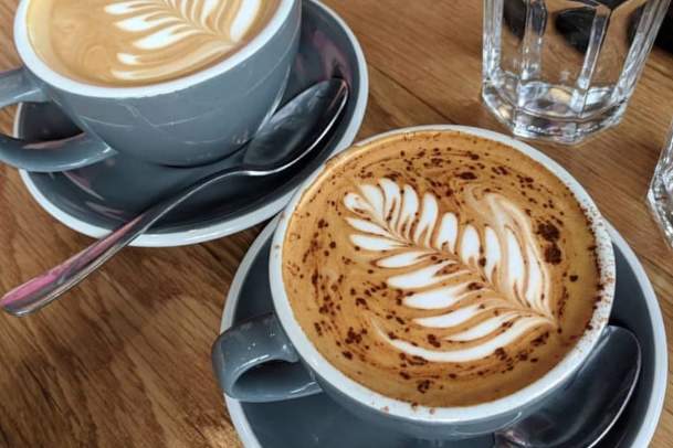 Two cups of coffee with designs from St. Kilda