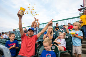 Family cheering and celebrating in the stands at an Iowa Cubs game