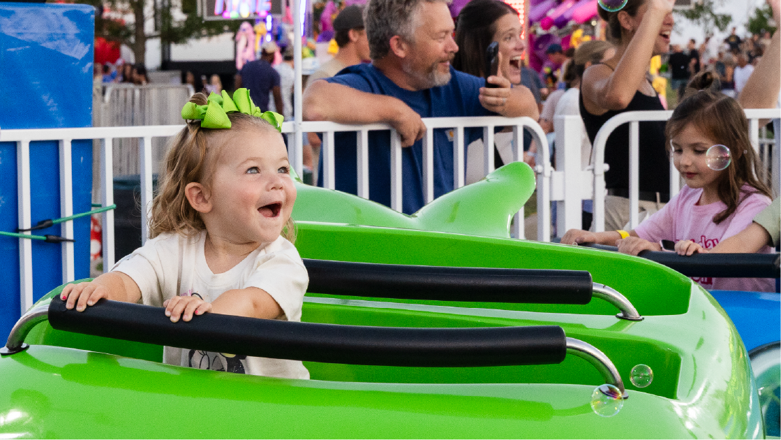 A little girl looks with excitement while riding a ride at the Iowa State Fair.