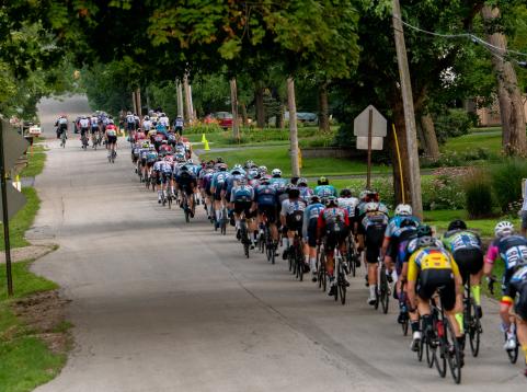 Professional cyclists racing down street during criterium race