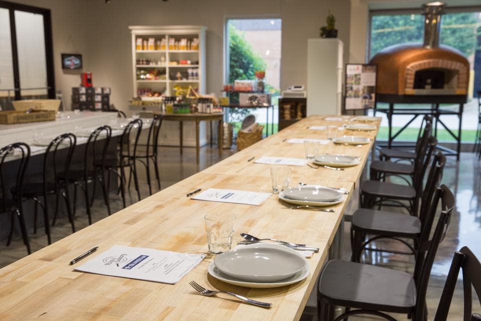 Interior of the North American Pizza Academy kitchen space with a long wooden table set for dining
