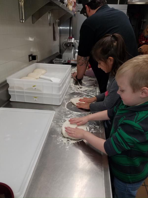 children taking a pizza making class