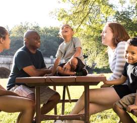 Family sitting at a park picnic table in Frederick, MD