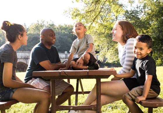 Family sitting at a park picnic table in Frederick, MD