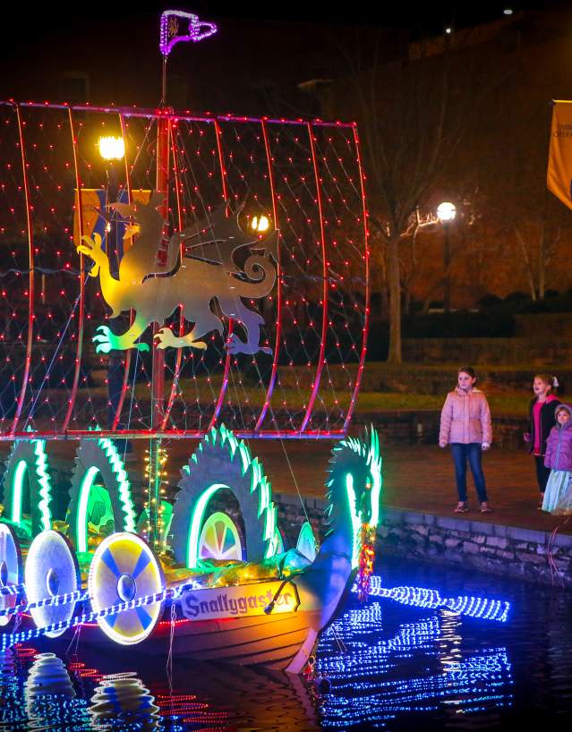 Family watching lighted boats at the Sailing Through The Winter Solstice event