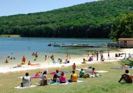 Visitors relax on the beach and enjoy swimming in the lake.