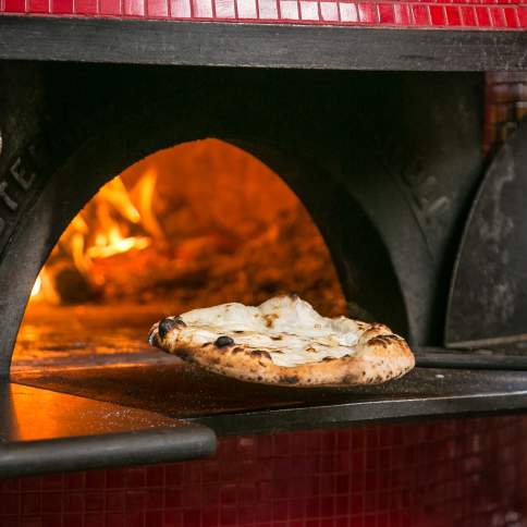Pizza coming out of the wood fire oven at Pistarro's