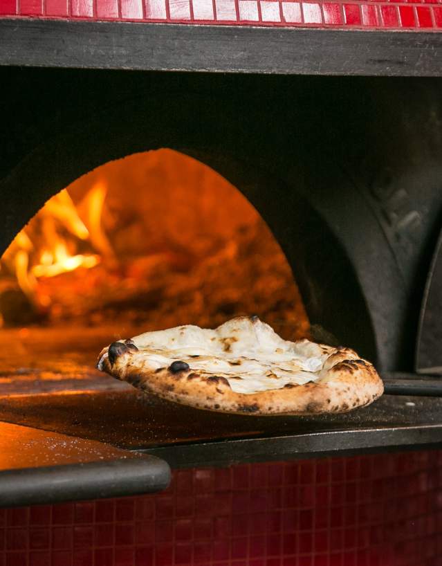 Pizza coming out of the wood fire oven at Pistarro's