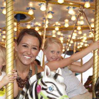 Mother and daughters riding a carousel