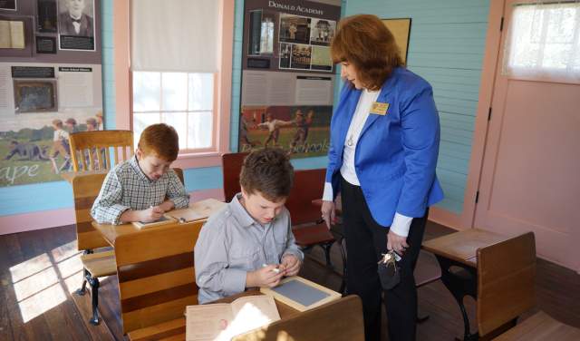 Kids learning in the Donald Schoolhouse, which is part of the Settlement to City Museums in Grapevine, Texas