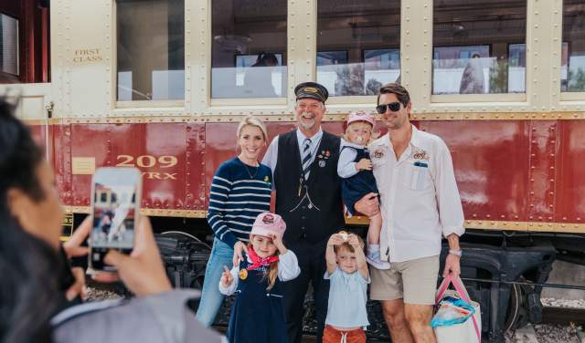 A family taking a picture to remember their time onboard the Grapevine Vintage Railroad in Grapevine, Texas