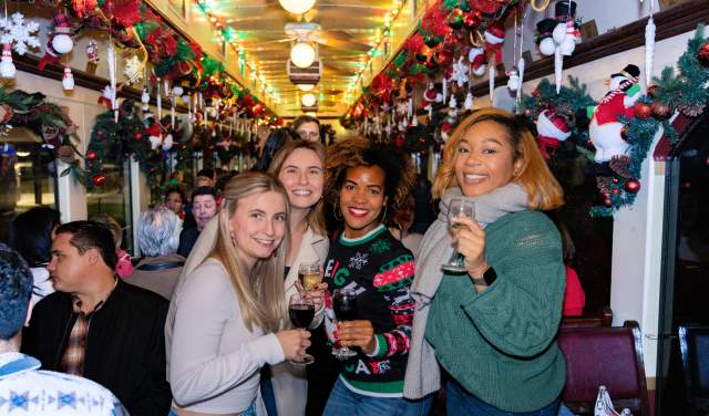 People on board Grapevine Vintage Railroad's Christmas Wine Train during the Christmas Capital of Texas