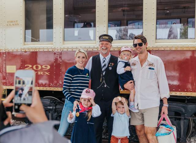 A family taking a picture to remember their time onboard the Grapevine Vintage Railroad in Grapevine, Texas