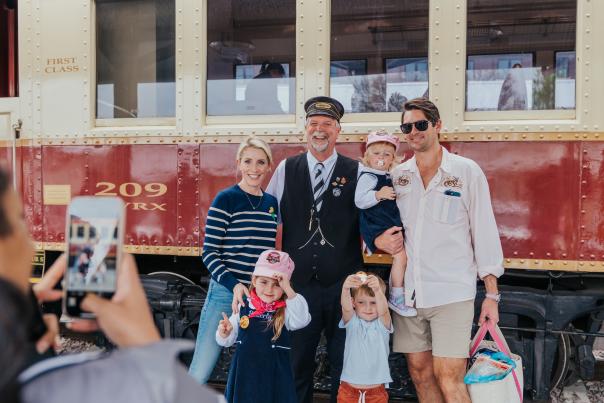 A family taking a picture to remember their time onboard the Grapevine Vintage Railroad in Grapevine, Texas
