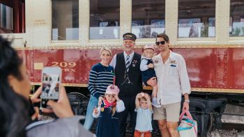 A family taking a picture to remember their time onboard the Grapevine Vintage Railroad in Grapevine, Texas