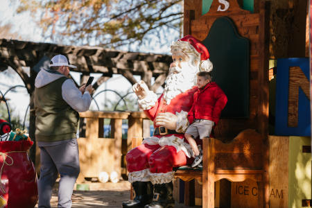 Christmas Capital of Texas kids takes picture with Santa statue