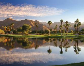 Beautiful lake at Indian Wells Golf Resort with the mountains, palm trees and green grass.