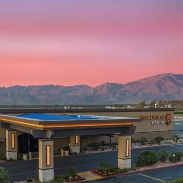 Augustine Casino exterior photo with sunset behind.