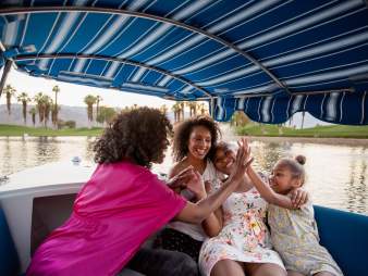 Mother and daughters on gondola on lake
