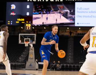Basketball players on the court at Acrisure Arena.