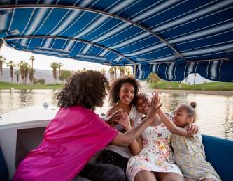 Mother and daughters on gondola on lake