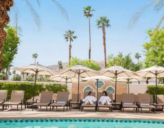 Two woman laying by the pool at Omni Rancho Mirage.