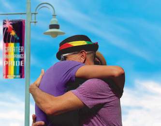 Couple hugging under GPS Pride flag
