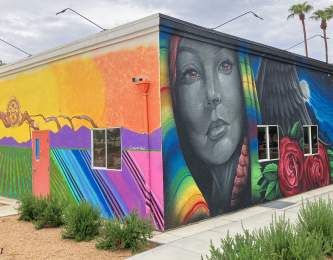 Three different colorful murals are painted on the sides of two walls at Coachella City Hall.