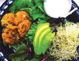 Plate filled with healthy greens, avocado and sprouts